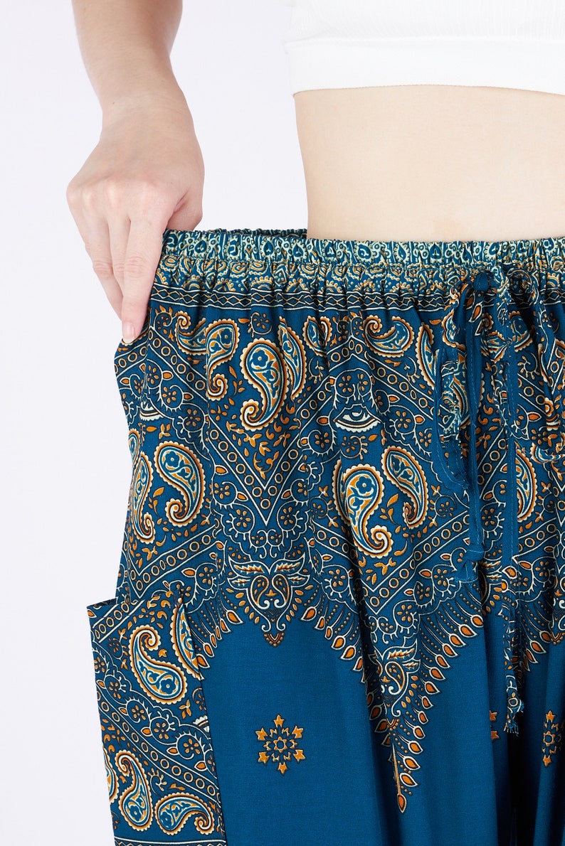 K&ouml;nnte beinhalten: Weit geschnittene Hose in tiefem Petrolblau mit einem komplizierten Paisley-Muster in Orange-, Wei&szlig;- und Dunkelblaut&ouml;nen. Die Hose verf&uuml;gt &uuml;ber einen elastischen Bund mit passendem Stoff-Kordelzug und seitlichen Eingrifftaschen.