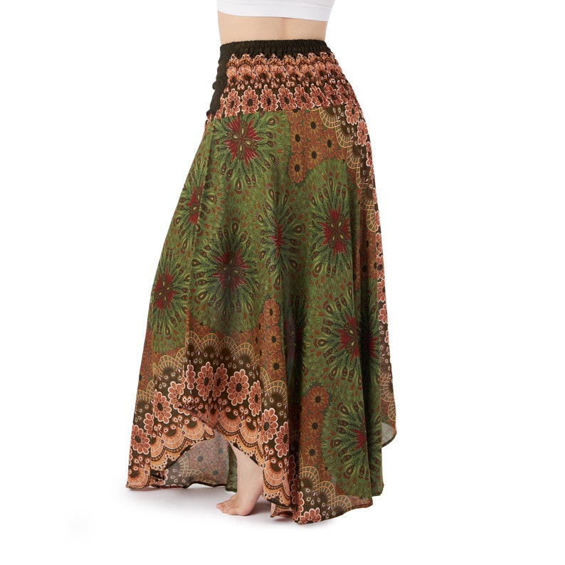 Puede incluir: Una falda larga estampada en tonos verdes, marrones y rojos. La falda presenta un dobladillo alto-bajo y una cintura el&aacute;stica. La tela est&aacute; adornada con un dise&ntilde;o floral e inspirado en mandalas, creando una est&eacute;tica bohemia.
