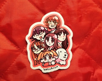 Puede incluir: Una pegatina con un grupo de chicas de dibujos animados con varios peinados y expresiones, junto con un perro blanco pequeño. La pegatina tiene un borde blanco y el texto "hellafroio" en la parte inferior. El fondo es una tela roja acolchada.