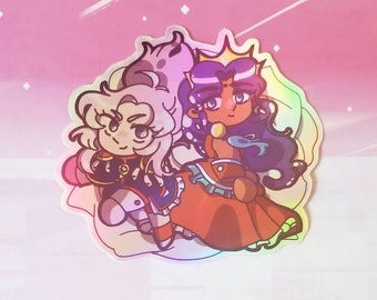 Puede incluir: Una pegatina holográfica con dos personajes de dibujos animados. Un personaje es una mujer con el pelo largo morado que lleva una corona y un vestido rojo. El otro personaje es una mujer con el pelo largo blanco que lleva un atuendo azul y blanco. Los personajes están sentados en una nube.