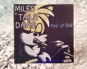 Puede incluir: Una portada de álbum negra y amarilla con el texto "MILES "TAILS" DAVIS" y "Kind of Blue". La portada presenta un personaje de dibujos animados tocando el saxofón.