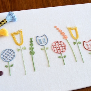 Crewel Blooms Handstickmuster. Ein Design der kleinen Blumen mit jakobinischen Sticktechniken, aber mit einem modernen Touch