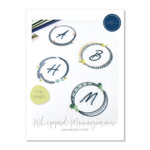May include: A white paper with four embroidered monograms: A, B, H, and M, each within a circular wreath. The text "Whipped Monograms" and "Hand Embroidery Pattern" are below the monograms. A logo in a navy blue circle is in the upper right corner.