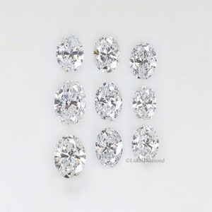 May include: Nine oval-shaped diamonds arranged in three rows on a white background.  The diamonds are clear and sparkly.