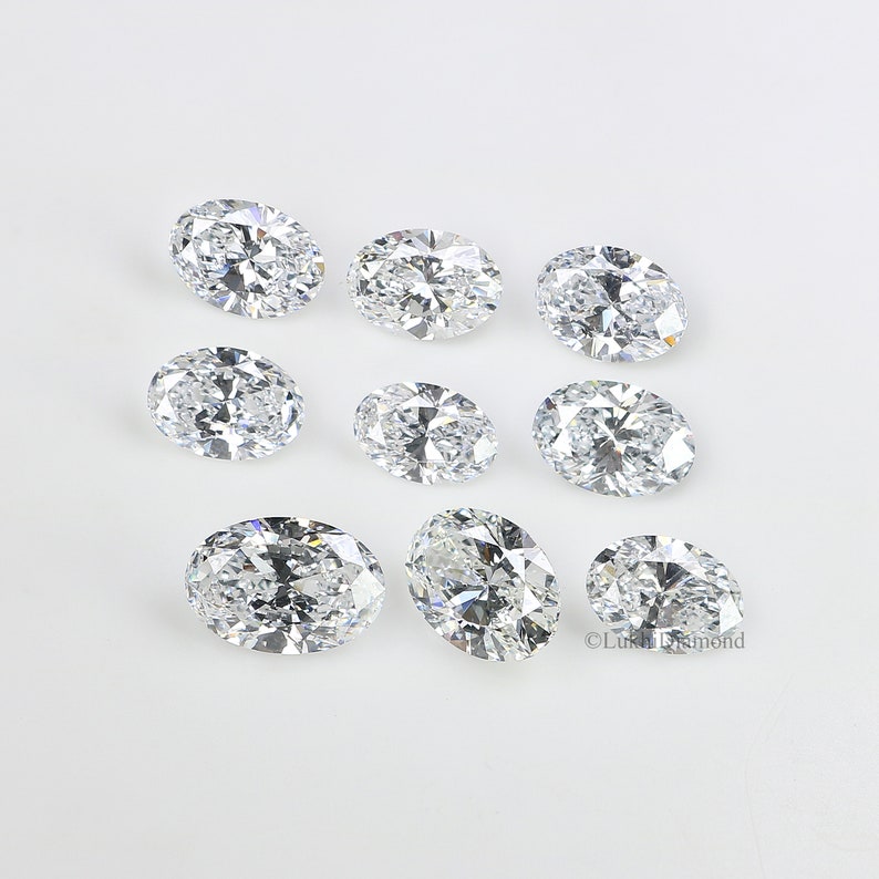 May include: Ten oval-shaped, clear, faceted gemstones on a white background.