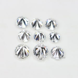 May include: A collection of eight round, clear, faceted gemstones. The gemstones are arranged in two rows on a white surface.