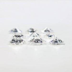 May include: A group of eight clear, round, faceted diamonds on a white background.