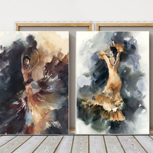 May include: Two framed watercolor paintings of flamenco dancers. The dancers are depicted in flowing dresses with dynamic poses, set against a backdrop of dark and light washes of color. The artwork is displayed on a wooden floor.