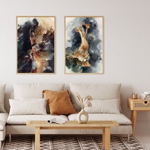 May include: Two framed watercolor paintings of flamenco dancers. The dancers are depicted in flowing dresses with dynamic poses, set against a backdrop of dark and golden hues. The artwork is displayed above a beige sofa with decorative pillows.