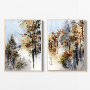 Pu&ograve; includere: Due dipinti ad acquerello incorniciati raffiguranti una scena di foresta. L'opera presenta alberi con foglie marroni e arancioni, su uno sfondo blu e bianco tenue. I dipinti sono in cornici di legno color chiaro.
