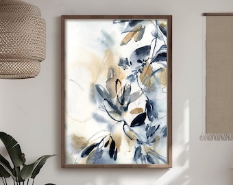 May include: Abstract watercolor painting in a wooden frame. The artwork features a botanical design with blue, gold, and beige hues. The painting has a soft, flowing style, with organic shapes and delicate lines. The frame is a warm brown color.