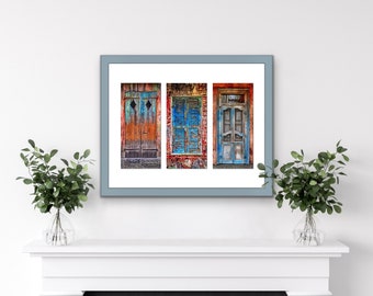 May include: A framed print of three vintage doors, each with a unique color scheme and design. The doors are set against a brick wall background.