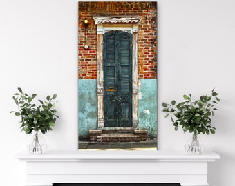 May include: A vintage green wooden door with shutters, set in a brick building with faded blue paint. The door has a small window and a brass door knocker.