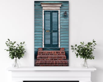 May include: A teal green door with white trim and shutters, a brick stoop, and the number "53" on the wall.