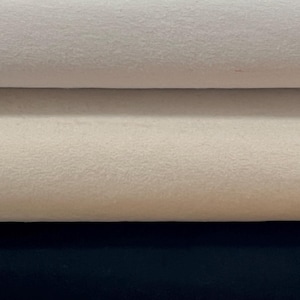 May include: Three fabric swatches, one white, one cream, and one black. The swatches are folded over each other.