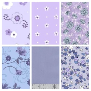 May include: A collection of six fabric swatches in shades of purple and blue. The patterns include floral designs with white, lavender, and blue flowers, as well as a solid lavender swatch. A ruler is visible on one swatch.