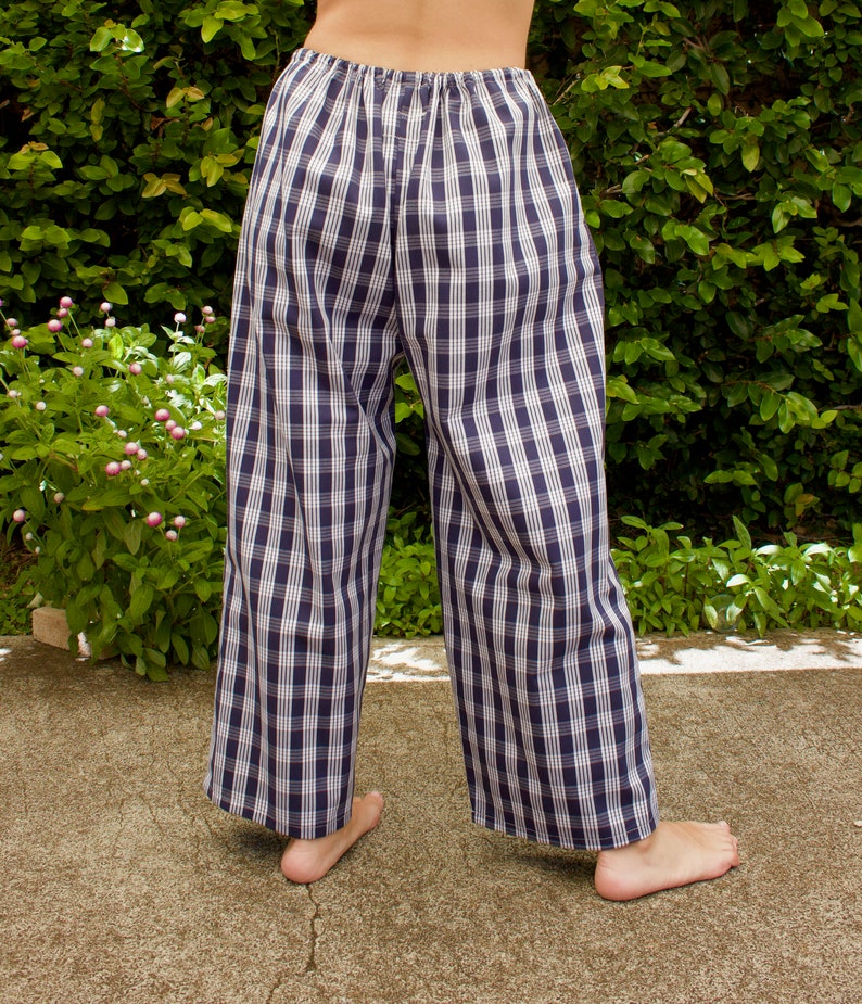 Pu&ograve; includere: Un paio di pantaloni da pigiama a quadri blu e bianchi con elastico in vita.