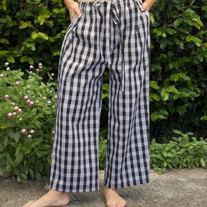 Pu&ograve; includere: Pantaloni larghi a gamba larga a quadri bianchi e neri con vita a coulisse.
