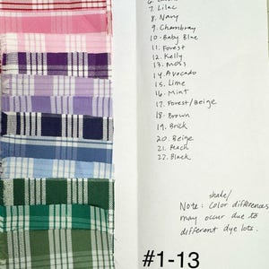 May include: A vertical column of thirteen fabric swatches featuring various plaid patterns in colors including red, pink, purple, blue, and green. A handwritten list labels the colors from 1 to 22, with a note about dye lot shade differences.