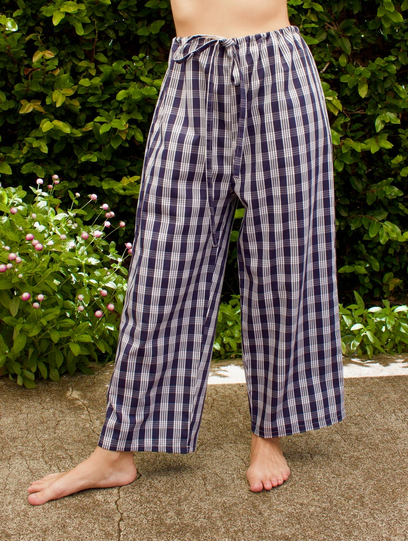 Pu&ograve; includere: Pantaloni a gamba larga con motivo a quadri blu e bianchi. I pantaloni hanno una vita con coulisse e una vestibilit&agrave; rilassata.