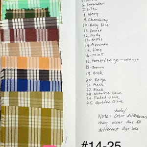 May include: A collection of twenty-five fabric swatches featuring various plaid patterns in colors including green, blue, brown, and beige. A handwritten list labels each swatch from 1 to 25, with a note about dye lots and the text #14-25 at the bottom.