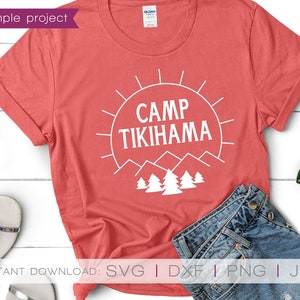 May include: A coral t-shirt with the white text "CAMP TIKIHAMA", a sun, mountains, and trees. The shirt is folded, with denim shorts and accessories visible. The words "sample project" are in the upper left corner. The image also includes the words "INSTANT DOWNLOAD".
