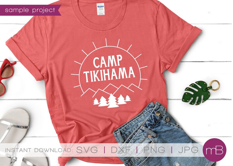 May include: A coral t-shirt with the white text "CAMP TIKIHAMA", a sun, mountains, and trees. The shirt is folded, with denim shorts and accessories visible. The words "sample project" are in the upper left corner. The image also includes the words "INSTANT DOWNLOAD".