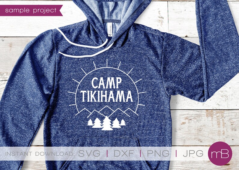 May include: A navy blue hoodie featuring the text "CAMP TIKIHAMA" in white, set within a sunburst design, with mountain and tree graphics. The hoodie has a drawstring and a front pocket.