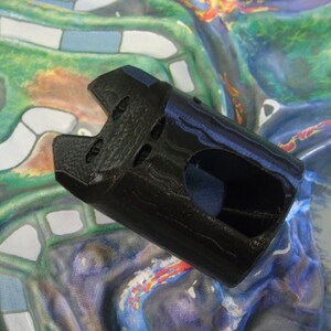May include: Black plastic castle tower game piece with a textured surface and a hole in the front.