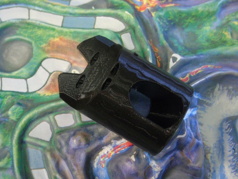 May include: Black plastic castle tower game piece with a textured surface and a hole in the front.