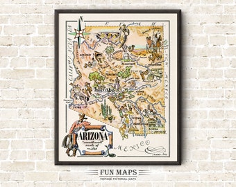 May include: A framed vintage pictorial map of Arizona, featuring illustrations of landmarks and activities. The map includes the text "ARIZONA" and "FUN MAPS". The map is in a black frame and is displayed against a brick wall.