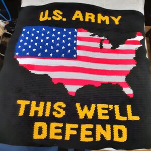 May include: A black crocheted blanket with a red, white, and blue American flag in the shape of the United States. The text "U.S. ARMY" is at the top of the blanket and the text "THIS WE'LL DEFEND" is at the bottom.