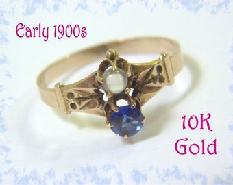May include: A vintage 10K gold ring with a blue sapphire and a pearl. The ring is from the early 1900s.