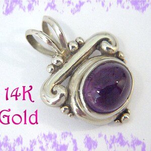 May include: A 14K gold pendant featuring a polished, oval-shaped, deep purple gemstone. The pendant has a swirling, ornate design with small, spherical accents. The text "14K Gold" is displayed in pink.