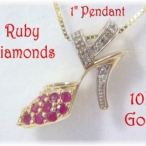 May include: A gold pendant shaped like a high-heeled shoe, set with ruby gemstones and diamonds. The pendant hangs from a gold chain. The image text reads "Ruby Diamonds", "1" Pendant", and "10K Gold".
