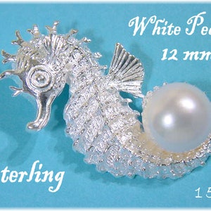 May include: A sterling silver seahorse pendant with a white pearl. The seahorse is intricately detailed, with a large pearl measuring 12 mm. The pendant is 4.1 cm in length. The word "Sterling" is written on the image.