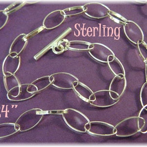 May include: A silver chain necklace with oval links. The chain is 24 inches long and has a toggle clasp. The chain is labeled "Sterling".