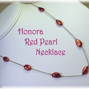 May include: A Honora Red Pearl Necklace displayed on a white mannequin. The necklace features oval-shaped red pearls strung on a delicate silver chain. The text "Honora Red Pearl Necklace" is displayed in pink.