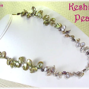 May include: A 24 inch necklace made with keshi pearls. The pearls are a mix of green, brown, and white, and are strung on a silver chain.