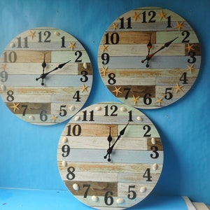 May include: Three round wall clocks with a beach theme. Each clock has a wooden background with blue and white stripes and features seashells and starfish. The clock faces are white with black numbers and hands.