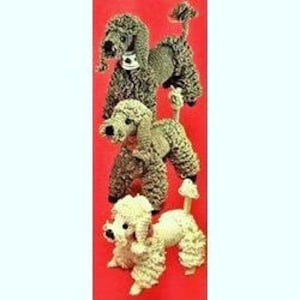 May include: Three crocheted poodle dog toys in different colors: gray, brown, and white. The poodles are standing on a red background.