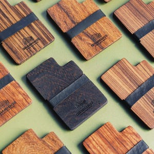Puede incluir: Varias carteras de madera con una banda el&aacute;stica negra. Cada cartera tiene el logotipo "GRAINHAUS" impreso en la parte delantera.