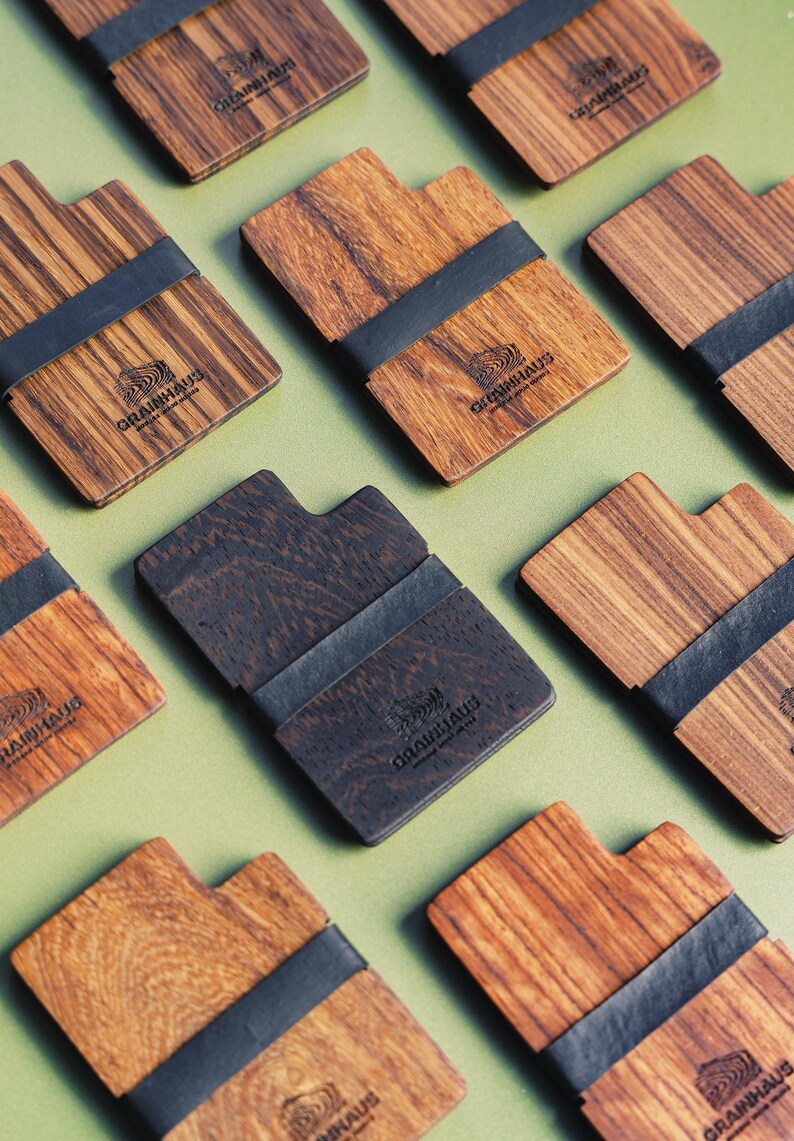 Puede incluir: Varias carteras de madera con una banda el&aacute;stica negra. Cada cartera tiene el logotipo "GRAINHAUS" impreso en la parte delantera.