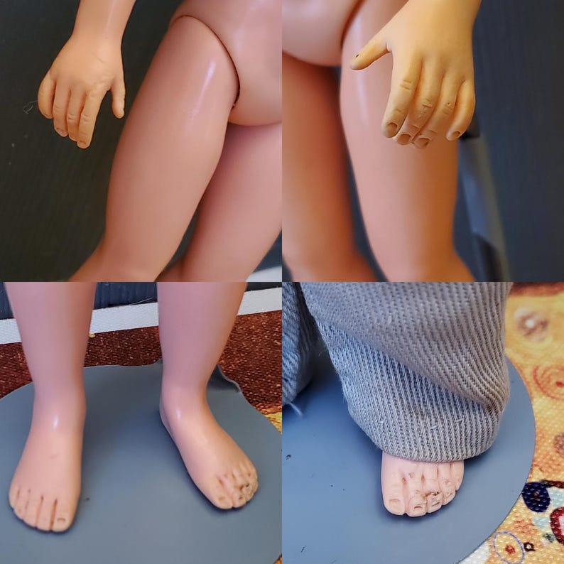 May include: Close-up of a doll's legs and feet. The doll has pale skin and is wearing grey trousers. The doll's feet are bare and have five toes each.