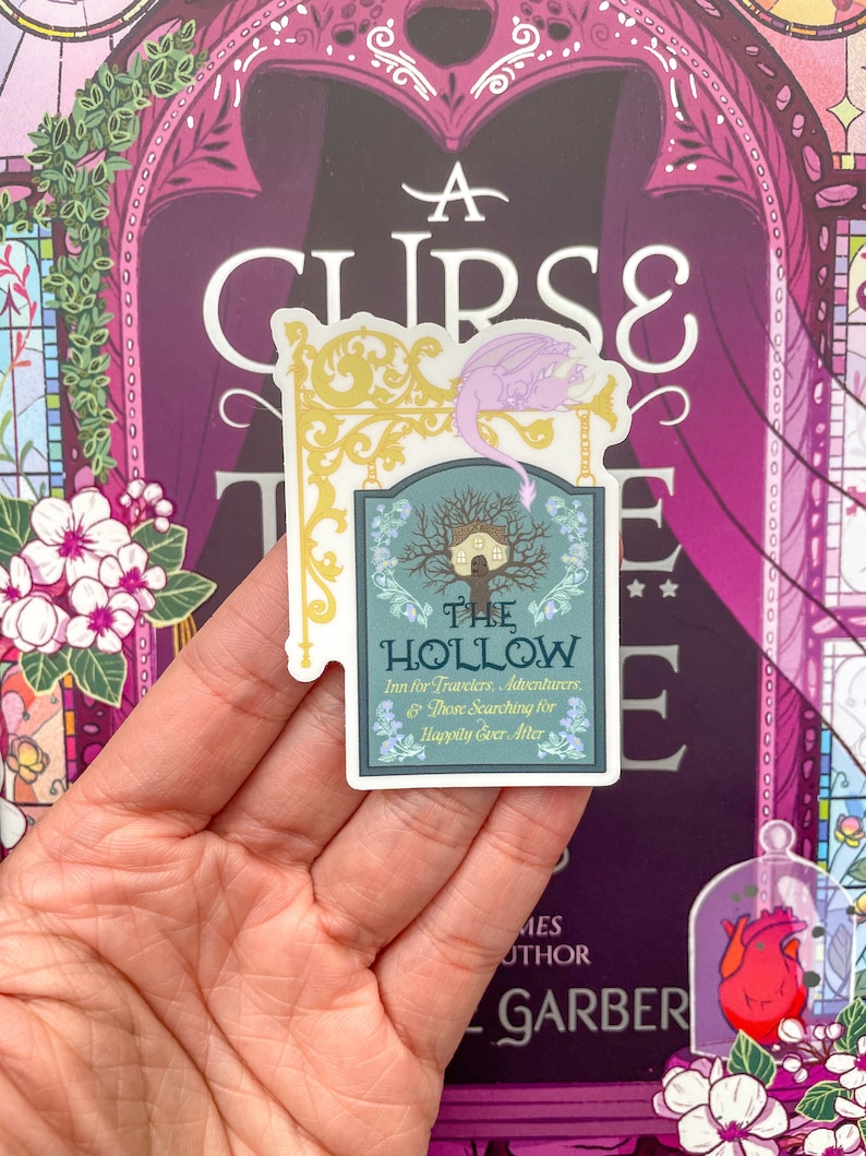 May include: A sticker featuring a whimsical illustration of a house in a tree with a dragon perched on a sign that reads "The Hollow Inn for Travelers, Adventurers, & Those Searching for Happily Ever After."