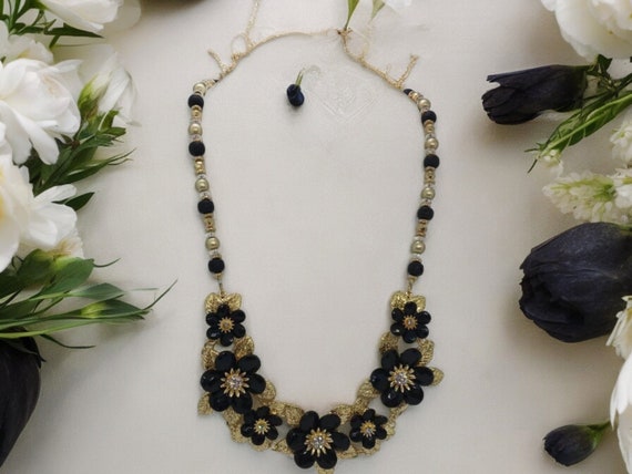 Collana Etnica Con Fiore Di Loto E Gemme Nere – Uno Stile Boho E Vintage Che Fa Subito Centro. Realizzata A Mano Con Materiali Di Qualità, Questa Collana Rotonda Con Ciondolo Scavato è L'accessorio Perfetto Per Dare Carattere A Qualsiasi Look.