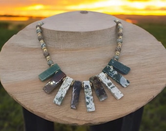 May include: A green, brown, and white agate stone necklace with gold accents. The necklace features a fan-shaped design with multiple rectangular stones.