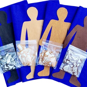 May include: Three felt cutouts of people in black, brown, and tan on a blue felt background. Each cutout has a plastic bag with white felt pieces inside.