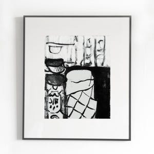 May include: Black and white abstract art print in a black frame. The artwork features a still life composition with various shapes and forms, including cylindrical and geometric elements. The style is reminiscent of ink wash painting.