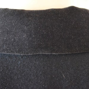 May include: Close-up of a black velvet collar on a garment. The collar is soft and plush, with a subtle sheen.